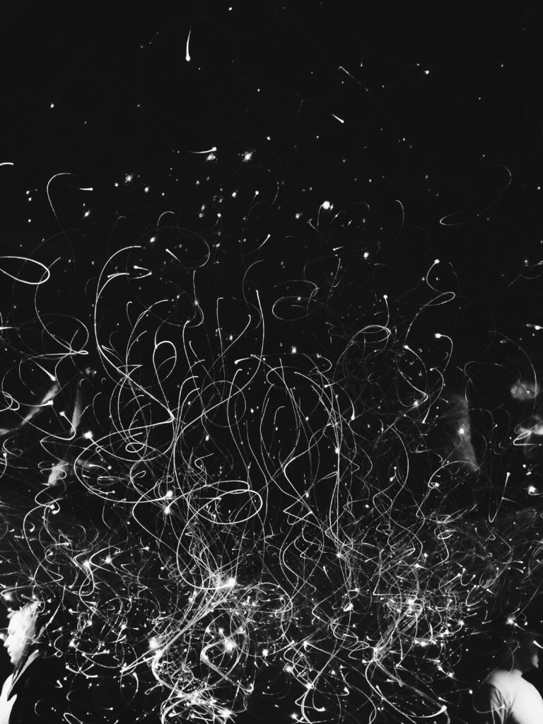 Black background, white specs and scribbles, with red wording that reads, "Color & Clarity: Artists Helping Us Through the Chaos"